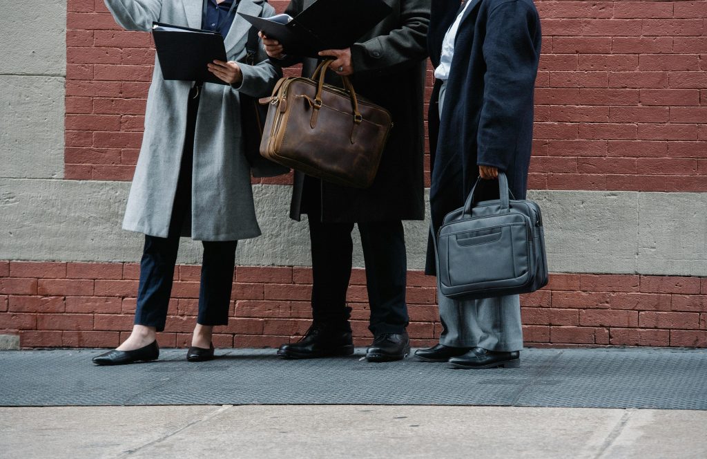 pexels-photo-5668440-5668440 Crop unrecognizable managers in stylish formal outfits standing on city street with document folders and briefcases in hands and discussing new business plans